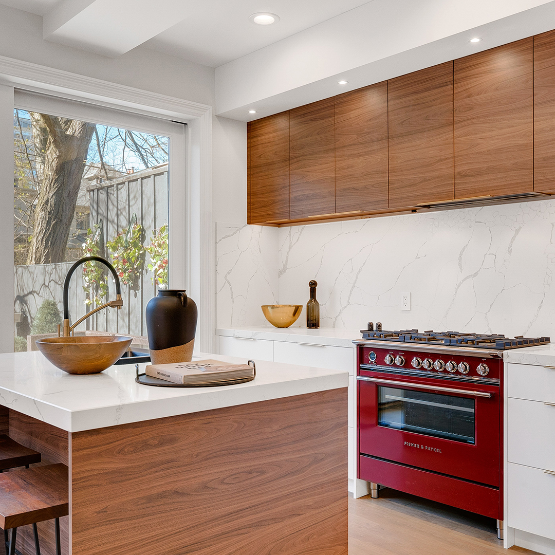 Kitchen with with white countertops and a red stove